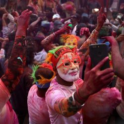 Un hombre que lleva una máscara del primer ministro de la India, Narendra Modi, se toma un selfie durante las celebraciones de Holi, el festival hindú de colores de primavera, en Varanasi. | Foto:Niharika Kulkarni / AFP