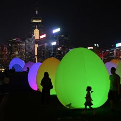 Una instalación titulada "Continuous" del colectivo de arte japonés teamLab, que presenta unos 200 objetos gigantes con forma de huevo que cambian de color con la música como parte de la iniciativa Art@Harbour, se ve en Tamar Park frente al puerto Victoria de Hong Kong. | Foto:PETER PARKS / AFP