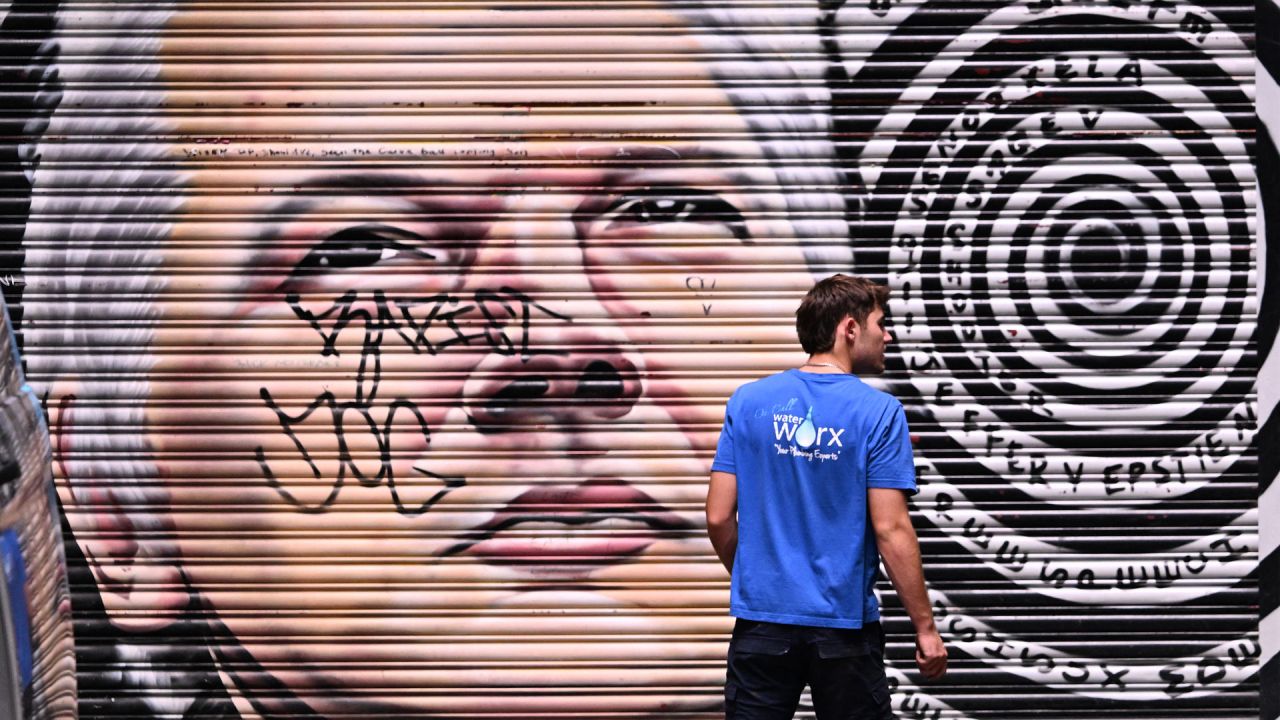 Un hombre pasa junto a un mural del fundador de WikiLeaks, Julian Assange, en una calle de Melbourne, Australia. | Foto:William West / AFP