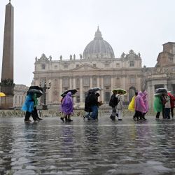 Los turistas caminan bajo una fuerte lluvia después de la audiencia general semanal en la plaza de San Pedro en el Vaticano. | Foto:Tiziana Fabi / AFP