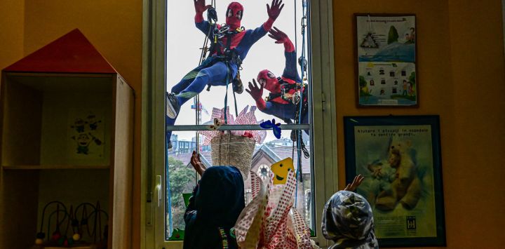 Personas vestidas como superhéroes entregan huevos de Pascua a niños hospitalizados en la sala de pediatría de la clínica De Marchi, en Milán, Italia.