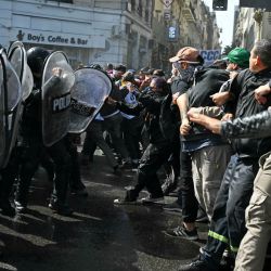 Integrantes de organizaciones sociales se enfrentan a la policía durante una manifestación contra las recientes medidas económicas introducidas por el gobierno del presidente Javier Milei en Buenos Aires. | Foto:LUIS ROBAYO / AFP