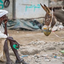 Un anciano espera para rellenar su tanque de agua tirado por un burro durante una crisis de agua en Port Sudan, en el Mar Rojo, estado de Sudán devastado por la guerra. | Foto:AFP