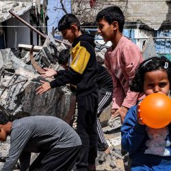 Una niña infla un globo entre los escombros de un edificio destruido en Rafah, en el sur de la Franja de Gaza, en medio del conflicto en curso en el territorio palestino entre Israel y el grupo militante Hamas. | Foto:MOHAMMED ABED / AFP