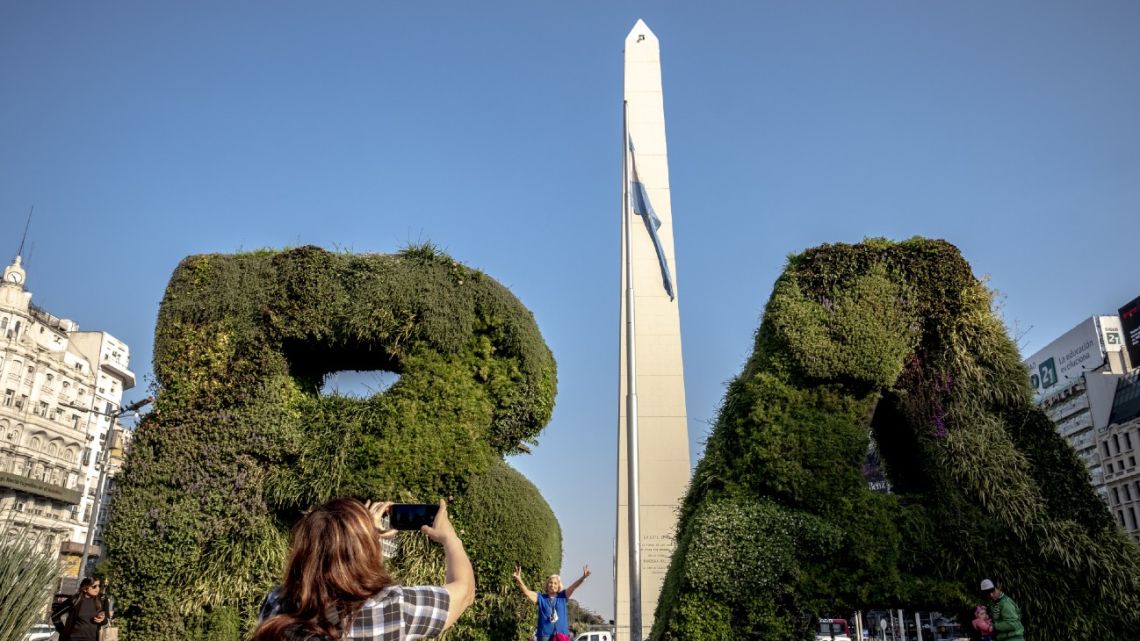 Tourists take photos in front of the Obelisk in Buenos Aires, on Wednesday, August 24, 2022.