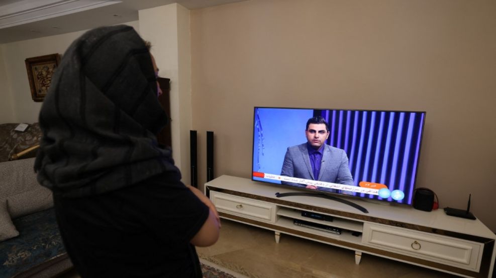 20240413 Una mujer iraní mira un canal de televisión de noticias iraní, que cubre las noticias del ataque de Irán a Israel, el 14 de abril de 2024
