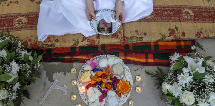 Ranyia Raid, miembro de la comunidad sabea-mandeana de Irak, posa para una fotografía mientras participa en un ritual de purificación durante su ceremonia nupcial en la ciudad kurda de Shaqlawa, a 45 kilómetros al norte de Arbil, la capital de la región autónoma del Kurdistán iraquí.