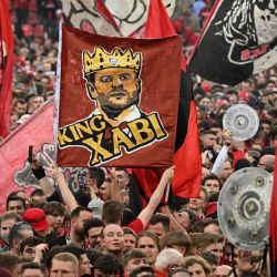Los aficionados de Leverkusen celebran en el campo con una pancarta del 'Rey Xabi' (el entrenador español del Bayer Leverkusen, Xabi Alonso) después del partido de fútbol de la primera división alemana de la Bundesliga Bayer 04 Leverkusen contra Werder Bremen en Leverkusen, Alemania occidental. | Foto:INA FASSBENDER / AFP