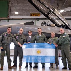 Los miembros de la delegación argentina, incluido el ministro de Defensa, Luis Alfonso Petri, sostienen su bandera nacional mientras posan frente a un caza F-16 durante un evento de prensa al margen de la firma de un acuerdo sobre la compra de aviones F-16 daneses. en la Base Aérea de Skrydstrup, Dinamarca. Argentina firmó un contrato para comprar 24 aviones de combate daneses F-16. | Foto:Bo Amstrup / Ritzau Scanpix / AFP
