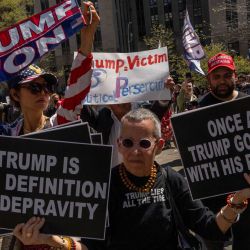 Manifestantes pro-Trump y anti-Trump sostienen carteles frente al Tribunal Penal de Manhattan mientras el expresidente estadounidense Donald Trump asiste al primer día de su juicio por supuestamente encubrir pagos de silencio relacionados con relaciones extramatrimoniales, en la ciudad de Nueva York. | Foto:Adam Gray / AFP