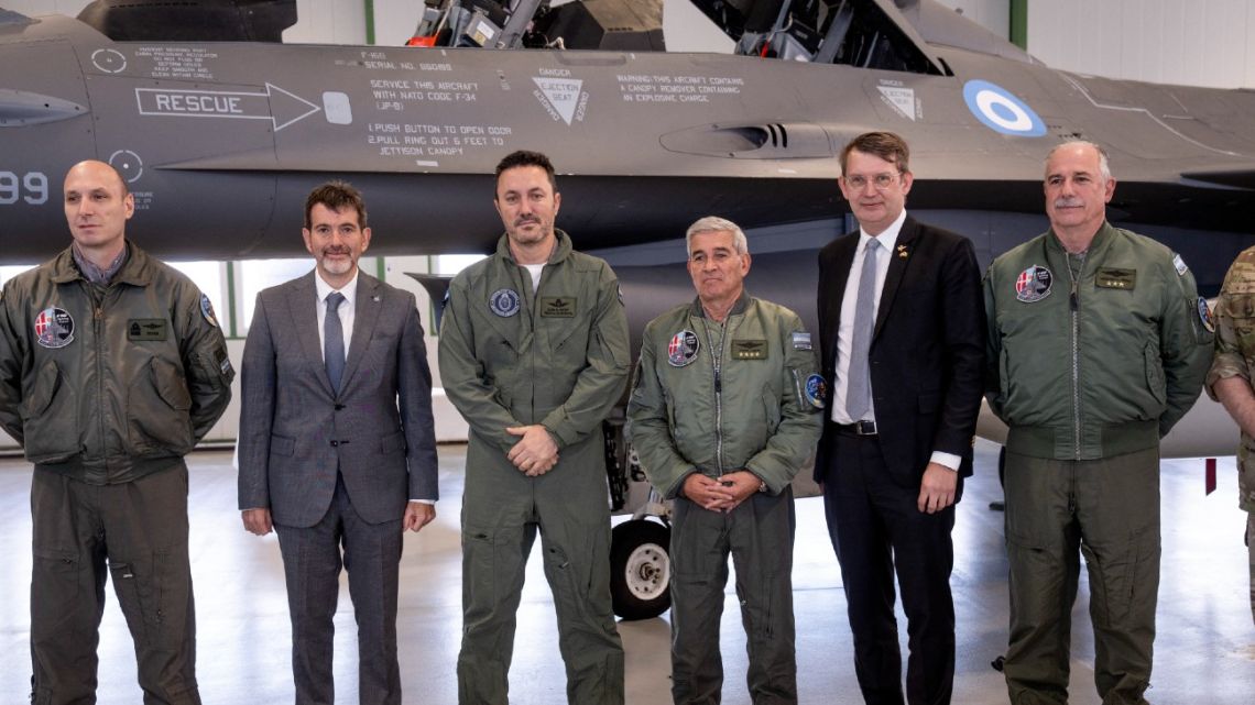 Argentina's Defence Minister Luis Alfonso Petri, Denmark's Defence Minister Troels Lund Poulsen and other delegation members pose in front of one of the F-16 planes Argentina is buying from Denmark during a press event at Skrydstrup Air Base, Denmark, on April 16, 2024. 