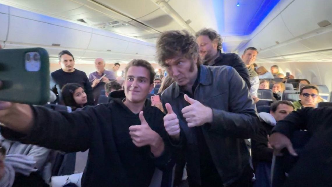 President Javier Milei, pictured on a commercial international flight posing for selfie with supporters.