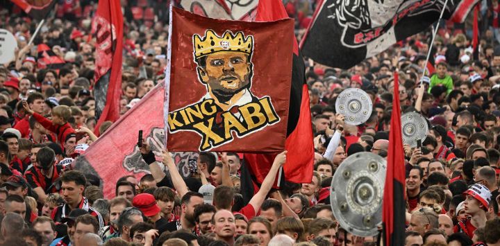 Los aficionados de Leverkusen celebran en el campo con una pancarta del 'Rey Xabi' (el entrenador español del Bayer Leverkusen, Xabi Alonso) después del partido de fútbol de la primera división alemana de la Bundesliga Bayer 04 Leverkusen contra Werder Bremen en Leverkusen, Alemania occidental.