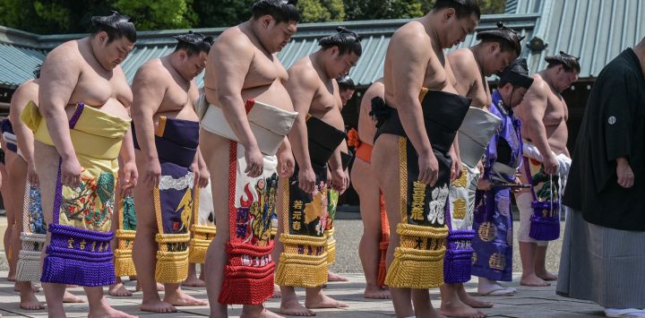 Los luchadores de sumo de alto rango se inclinan mientras participan en una ceremonia tradicional sintoísta en el Santuario Yasukuni en Tokio.