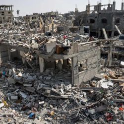 La gente inspecciona los daños entre los escombros de los edificios destruidos durante el bombardeo israelí en Khan Yunis, en el sur de la Franja de Gaza, mientras continúan los combates entre Israel y el grupo militante palestino Hamás. | Foto:AFP