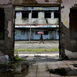 Se ve a un hombre pasando por un edificio abandonado en el distrito Chinatown de Honiara, la capital de las Islas Salomón. | Foto:Saeed Khan / AFP