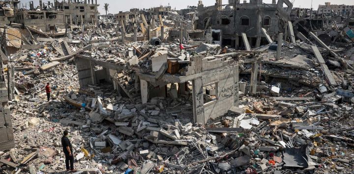 La gente inspecciona los daños entre los escombros de los edificios destruidos durante el bombardeo israelí en Khan Yunis, en el sur de la Franja de Gaza, mientras continúan los combates entre Israel y el grupo militante palestino Hamás.