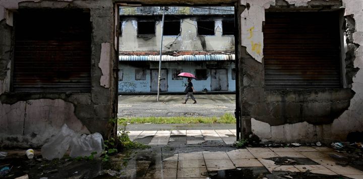 Se ve a un hombre pasando por un edificio abandonado en el distrito Chinatown de Honiara, la capital de las Islas Salomón.