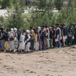 Afganos hacen cola mientras esperan frente a una oficina de pasaportes en Hera. | Foto:Mohsen Karimi / AFP