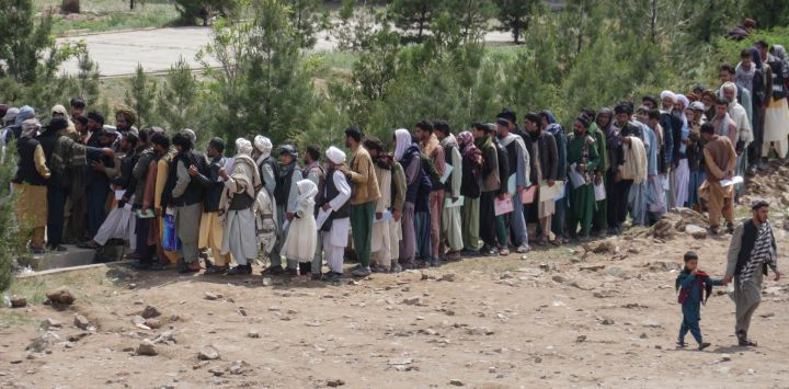 Afganos hacen cola mientras esperan frente a una oficina de pasaportes en Hera.