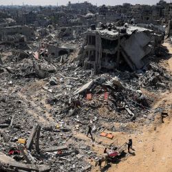 La gente busca artículos recuperables entre los escombros de los edificios destruidos durante el bombardeo israelí en Khan Yunis, en el sur de la Franja de Gaza, mientras continúan los combates entre Israel y el grupo militante palestino Hamás. | Foto:AFP
