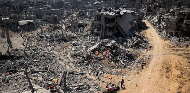 La gente busca artículos recuperables entre los escombros de los edificios destruidos durante el bombardeo israelí en Khan Yunis, en el sur de la Franja de Gaza, mientras continúan los combates entre Israel y el grupo militante palestino Hamás.