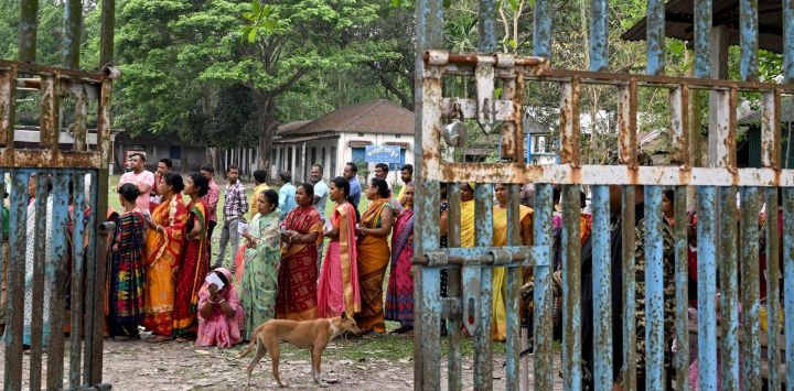 La gente hace cola para emitir sus votos cuando comienza la votación en la primera fase de las elecciones generales de la India en un colegio electoral en la aldea de Kalamati.