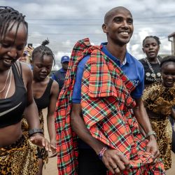 El corredor retirado somalí-británico Mo Farah baila con jóvenes bailarines kenianos durante su llegada para participar en el torneo anual de la Copa de Fútbol Mo Farah para inmigrantes urbanos en la Asociación de Deportes Juveniles Mathare en Nairobi, Kenia. | Foto:LUIS TATO/AFP