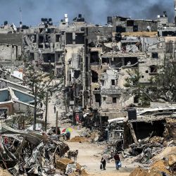 La gente pasa junto a edificios destruidos en Khan Yunis, en el sur de la Franja de Gaza, en medio del conflicto en curso en el territorio palestino entre Israel y el grupo militante Hamas. | Foto:AFP