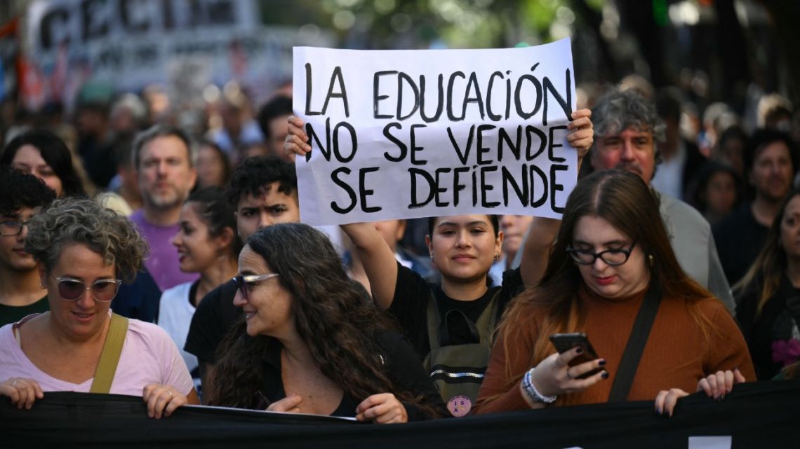 A demonstrator holds a sign that reads 'Education is not for sale, it is defended' during a march in protest of the budget adjustment to public universities in Buenos Aires on April 23, 2024.
