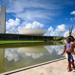 Un indígena brasileño llega al Congreso Nacional para asistir a una sesión en el marco del Acampamento Terra Livre (Campamento Tierra Libre) en Brasilia. Miles de indígenas participan en la mayor manifestación anual para exigir sus derechos. | Foto:EVARISTO SA / AFP