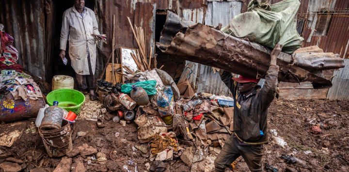 Un hombre recoge algunas de sus pertenencias mientras otros cargan varios materiales después de que sus casas fueran destruidas por las inundaciones tras las lluvias torrenciales en el asentamiento informal Mathare en Nairobi, Kenia.