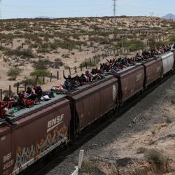 Migrantes de diferentes nacionalidades que buscan asilo en Estados Unidos viajan en vagones de carga del tren mexicano conocido como "La Bestia" cuando llegan a la ciudad fronteriza de Ciudad Juárez, en el estado de Chihuahua, México. | Foto:Herika Martínez / AFP