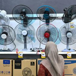 Una mujer mira los ventiladores a la venta en un centro comercial en medio de altas temperaturas en Kuala Lumpur. El calor extremo está abrasando partes del sur y sudeste de Asia, lo que ha provocado advertencias sanitarias por parte de las autoridades a medida que se registran altas temperaturas en toda la región. | Foto:Mohd Rasfan / AFP