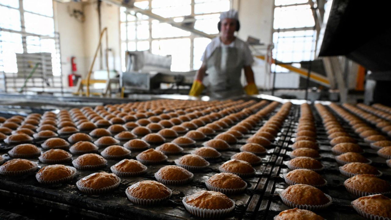 Un trabajador inspecciona los pastelitos que salen del horno en la fábrica de Dulcypas en La Matanza, provincia de Buenos Aires. | Foto:LUIS ROBAYO / AFP