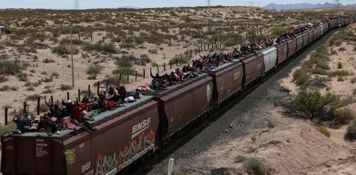 Migrantes de diferentes nacionalidades que buscan asilo en Estados Unidos viajan en vagones de carga del tren mexicano conocido como "La Bestia" cuando llegan a la ciudad fronteriza de Ciudad Juárez, en el estado de Chihuahua, México.