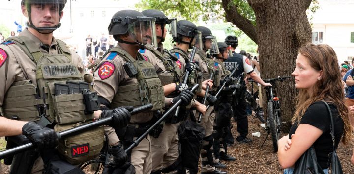 Un estudiante observa silenciosamente una fila de policías estatales de Texas mientras estudiantes pro palestinos protestan contra la guerra entre Israel y Hamas en el campus de la Universidad de Texas en Austin, Texas.