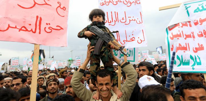 Un niño parado sobre los hombros de un hombre sostiene un rifle durante una manifestación pro-palestina y anti-israelí en Saná, la capital controlada por los hutíes, en medio del conflicto en curso en la Franja de Gaza entre Israel y el grupo militante palestino Hamás.