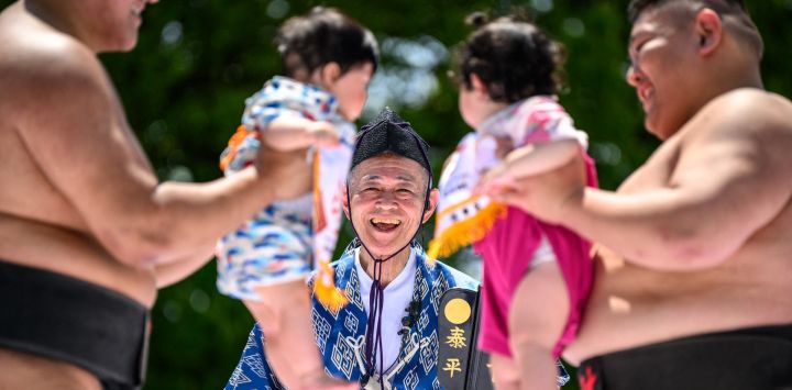 Los luchadores de sumo sostienen a los niños durante su partido de "sumo del bebé que llora" en el templo Sensoji en Tokio. Los padres japoneses creen que los luchadores de sumo pueden ayudar a que los bebés lloren y deseen crecer con buena salud.
