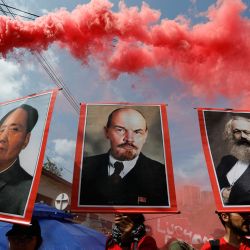 La gente muestra retratos de Mao Zedong, Lening y Marx durante una manifestación en Medellín, departamento de Antioquia, Colombia. | Foto:JAIME SALDARRIAGA / AFP