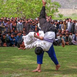 Los afganos se reúnen para ver competir a los luchadores tradicionales en un campo en el distrito de Baharak de la provincia de Badakhshan. | Foto:OMER ABRAR / AFP