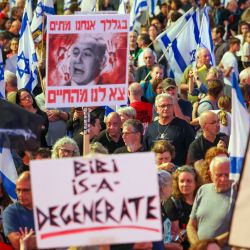 Los manifestantes sostienen pancartas y ondean banderas nacionales durante una manifestación antigubernamental en la ciudad costera israelí de Tel Aviv, en medio del conflicto en curso entre Israel y el grupo militante Hamas. | Foto:JACK GUEZ / AFP