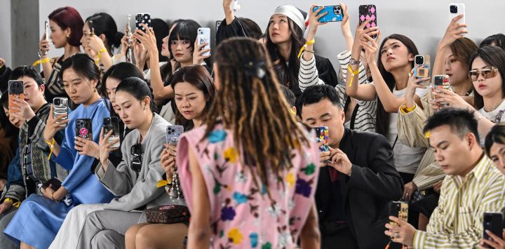 Los asistentes toman fotografías mientras una modelo presenta una creación durante el Louis Vuitton Voyager Show con la próxima colección Women's Prefall 2024 en el Long Museum West Bund en Shanghai.