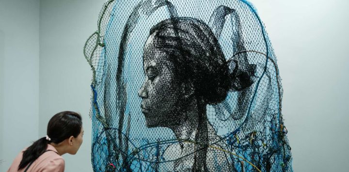 Un visitante observa la obra de arte del artista indonesio Iwan Yusuf titulada "Infinity" hecha con redes de pesca nuevas y usadas durante la feria de arte Jakarta Art Gardens en Yakarta.