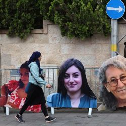 Una mujer pasa junto a grandes retratos recortados de cartón de mujeres israelíes rehenes en Gaza desde los ataques del 7 de octubre, creados por familiares y simpatizantes durante una protesta pidiendo su liberación frente a la residencia del Primer Ministro en Jerusalén. | Foto:GIL COHEN-MAGEN / AFP