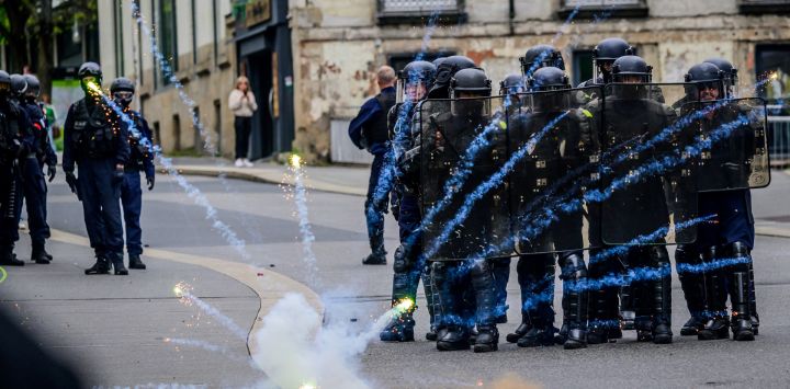 La policía antidisturbios se forma mientras recibe fuegos artificiales durante una manifestación en Nantes, oeste de Francia.
