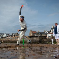 Los jugadores de Ship Inn CC y The South Street Swingers CC, un equipo formado por ex miembros del equipo de la Universidad de Edimburgo, juegan un partido de cricket en la playa de Elie, en la costa sur de Fife, en el este de Escocia. | Foto:Andy Buchanan / AFP