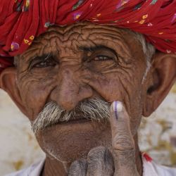 Un hombre muestra su dedo entintado después de emitir su voto en un colegio electoral durante la segunda fase de la votación en las elecciones generales de la India, en Ajmer. | Foto:Himanshu Sharma / AFP