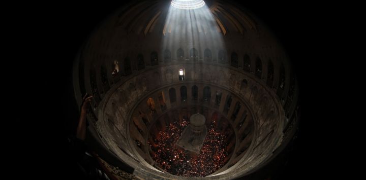 Los cristianos ortodoxos se reúnen con velas encendidas alrededor del Edículo, tradicionalmente considerado el lugar de enterramiento de Jesucristo, durante la ceremonia anual del Fuego Santo en la iglesia del Santo Sepulcro de Jerusalén.