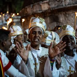 Los cristianos ortodoxos etíopes se reúnen con velas encendidas durante la ceremonia del Fuego Santo en el Monasterio de Deir Al-Sultan en el techo de la iglesia del Santo Sepulcro en la Ciudad Vieja de Jerusalén. | Foto:RONALDO SCHEMIDT / AFP